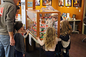 Children looking at LEGO® structure in a glass case