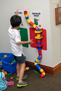 Child  building a tall LEGO® tube